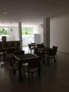 a dining room with tables and chairs and a counter at Apartamento Praia Grande 301 in Ubatuba