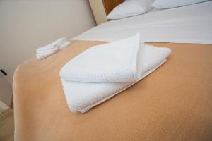 uma pilha de toalhas brancas sentadas numa cama em Beach Studio Apartment Marija em Kaštela