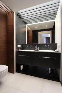 a bathroom with a black sink and a mirror at Lubicz Luxury Apartment in Kraków
