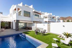 a villa with a swimming pool and a house at Portofino Resort in Arona