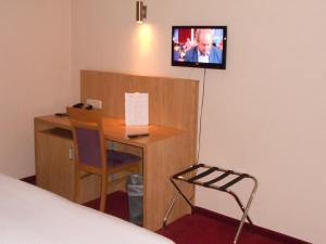 a bed room with a desk and a tv at Hotel Euro Capital Brussels in Brussels