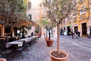una calle vacía con mesas, sillas y árboles en Appartamento Lavatore, en Roma