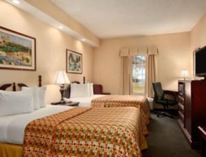 a hotel room with two beds and a television at Howard Johnson by Wyndham Jackson in Jackson