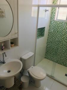 a bathroom with a toilet and a sink and a shower at Apartamento frente Mar Santos in Santos