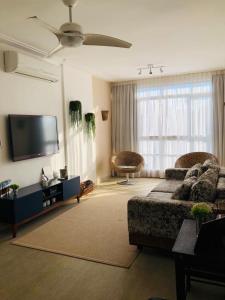 sala de estar con sofá y TV de pantalla plana en Apartamento frente Mar Santos en Santos