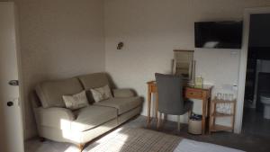 a living room with a couch and a desk at Haisthorpe Guest House in Windermere