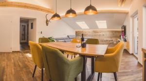 een eetkamer met een houten tafel en gele stoelen bij Apartment NinetyFour in Annaberg im Lammertal