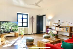 a living room with a tv and a red couch at La Fornace in Alessandria