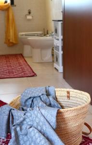 een badkamer met een mand met kleren op de vloer bij La Rosa dei Venti in Sennariolo