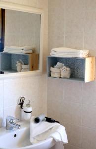 a bathroom with a sink and a mirror and towels at La Rosa dei Venti in Sennariolo