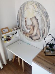 Zimmer mit einem weißen Tisch und einem Gemälde an der Wand in der Unterkunft Kamzík Donovaly in Donovaly