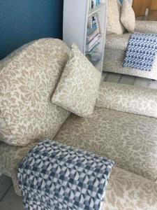 a couch with pillows on it in a living room at Beachside Apartment in Bangor