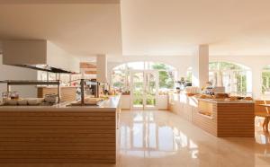 cocina grande con encimeras de madera y ventanas en Sol de Alcudia Apartamentos, en Puerto de Alcudia