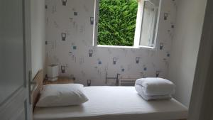 1 dormitorio con 1 cama blanca y ventana en Gîte près de Chambord, en Muides-sur-Loire