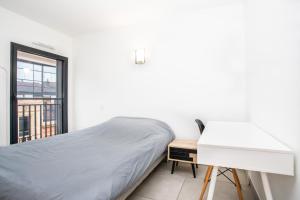 um quarto com uma cama, uma secretária e uma janela em 202 - Appartement Duplex Moderne - Jeanne d'Arc, Toulouse em Toulouse