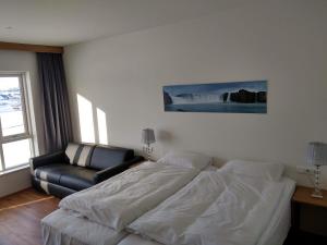 a bedroom with a bed and a leather couch at Hafdals Hotel in Akureyri
