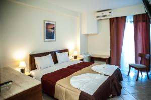 a hotel room with a large bed in a room at Hotel Aigli in Perea