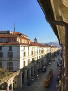 uitzicht op een straat met gebouwen en bussen bij Nido del Cuore in Turijn