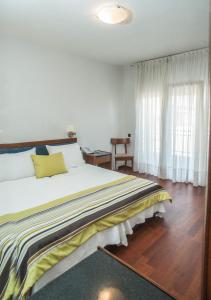um quarto com uma cama grande e uma janela em Hotel Aigli em Perea