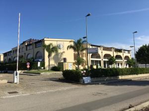 un edificio con palme di fronte a una strada di CASA VACANZE METAPONTO a Metaponto