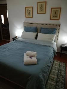 a bed with two towels sitting on top of it at A Casa da avó Custodinha in Bias do Norte