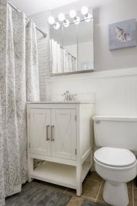 a white bathroom with a toilet and a mirror at Welcoming Barn, 2 BEDROOM & 1 Bath & Parking in Atlanta +31 photos