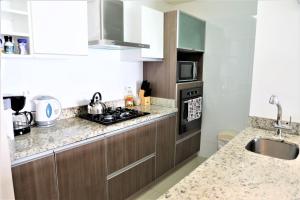 cocina con fregadero y fogones horno superior en Miraflores4Rent Upper Pardo, en Lima