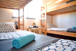 a blue towel laying on a bed in a room at Surf House Peniche in Baleal