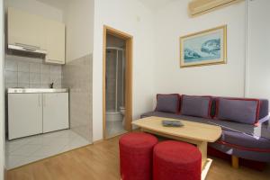 uma sala de estar com um sofá e uma mesa em Beach Studio Apartment Marija em Kaštela