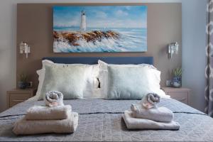 a bedroom with two towels on a bed with a lighthouse at Guesthouse Villa Diana in Makarska
