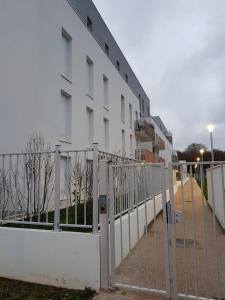 a white building with a fence in front of it at Private room CDG airport Parc Expo in Villepinte