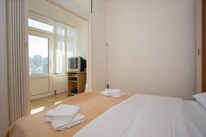 um quarto branco com uma cama com toalhas em Beach Studio Apartment Marija em Kaštela