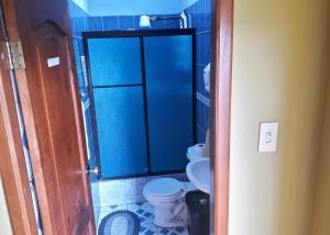 a bathroom with a toilet and a blue shower at Hostal Dorys Mar in Puerto Baquerizo Moreno +37 photos