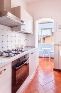 フィレンツェにあるFlorence Rooftop Apartmentsのキッチン(白いキャビネット、コンロ付)