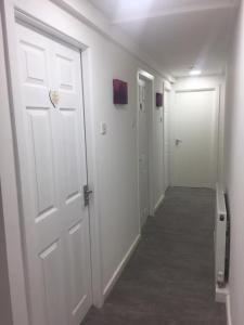 an empty hallway with a white door and a hallway at Sama's Stylish Apartment Room 1 in Manchester