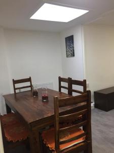 a wooden dining room table with two chairs and a light at Sama's Stylish Apartment Room 1 in Manchester
