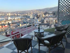 balcón con mesa, sillas y ciudad en Casa porteña en cerro Artilleria, en Valparaíso