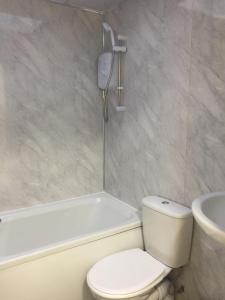a bathroom with a toilet and a tub and a sink at Sama's Stylish Room 3 in Manchester