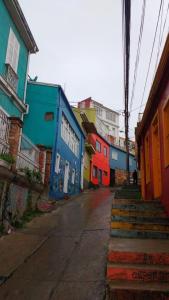 an empty street with colorful buildings and stairs at Casa porteña en cerro Artilleria in Valparaíso +9 photos