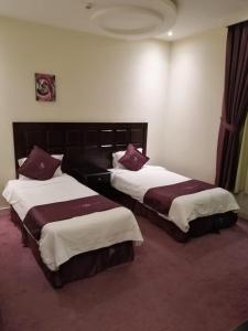 a hotel room with two beds in a room at Dorar Darea Hotel Apartments - Al Nafl in Riyadh