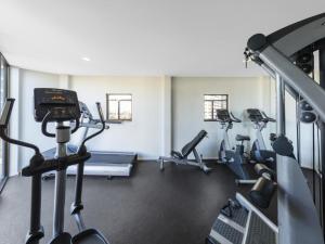 a gym with several treadmills and cardio machines at Apartment at College St in Sydney