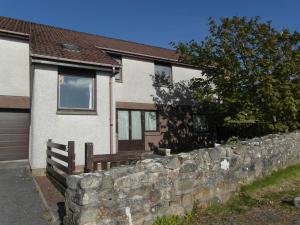 a stone retaining wall in front of a house at One bedroom self-contained accommodation in Lerwick
