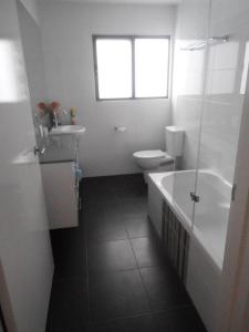 
a bathroom with a sink, toilet and tub at Gull Apartment in Strahan
