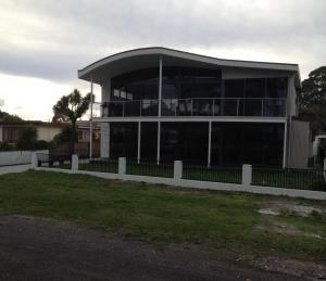 
a large white building with a large window at Gull Apartment in Strahan
