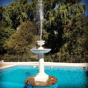 a fountain in front of a swimming pool at Rancho Grande Hotel in Villa General Belgrano