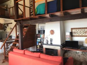 a living room with a red couch and a fireplace at Paradise House Over the Sea in Sesimbra