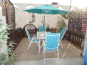 una mesa, sillas y una sombrilla en el patio en Playmar Sun Maspalomas, en Playa del Inglés