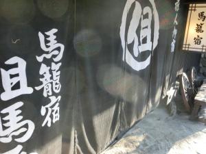 
a sign on a wall with graffiti on it at Tajimaya in Nakatsugawa

