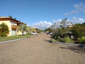 eine Kopfsteinpflasterstraße mit Autos auf einem Parkplatz in der Unterkunft Itacimirim - Quinta das Lagoas Residence in Itacimirim