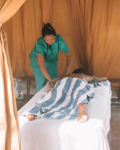 a woman standing next to a patient on a bed at El Nido Garden Resort in El Nido